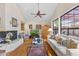 Bright living room with fireplace, ceiling fan, hardwood floors, and oversized window at 7525 E Gainey Ranch Rd # 164, Scottsdale, AZ 85258