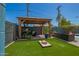 Relaxing backyard retreat featuring an outdoor seating area with a gazebo and lush artificial turf, ideal for entertaining at 8155 E Columbus Ave, Scottsdale, AZ 85251