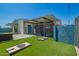 Backyard patio area features turf, a covered patio, a basketball hoop, and a cornhole game, perfect for outdoor activities at 8155 E Columbus Ave, Scottsdale, AZ 85251