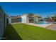 Backyard pool with turf, patio, privacy fence, white house and pergola, perfect for outdoor entertaining and relaxation at 8155 E Columbus Ave, Scottsdale, AZ 85251