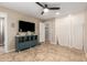 Relaxing bedroom featuring tile flooring, a ceiling fan, and access to an ensuite bathroom at 8155 E Columbus Ave, Scottsdale, AZ 85251
