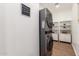 The laundry room area boasts modern, stacked washer and dryer units with shelves at 8155 E Columbus Ave, Scottsdale, AZ 85251