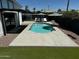Inviting backyard pool with lounge chairs, patio, and well-manicured artificial lawn, perfect for relaxation at 8155 E Columbus Ave, Scottsdale, AZ 85251