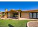Private backyard featuring covered patio, brick, seating, synthetic grass, and lush landscaping at 8355 E Vía De Los Libros --, Scottsdale, AZ 85258