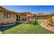 Serene backyard with brick, covered patio, manicured synthetic grass, and desert accents at 8355 E Vía De Los Libros --, Scottsdale, AZ 85258