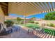 Back patio with brick flooring, seating, synthetic grass, and covered pergola at 8355 E Vía De Los Libros --, Scottsdale, AZ 85258