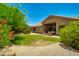 A large backyard with green grass, desert landscaping, and a covered patio with outdoor seating at 9038 E Calle De Valle Dr, Scottsdale, AZ 85255