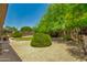 Spacious backyard with desert landscaping and a covered patio seating area at 9038 E Calle De Valle Dr, Scottsdale, AZ 85255