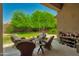 Covered patio with comfortable seating, accent pillows, and a view of the lush green yard and landscaping at 9038 E Calle De Valle Dr, Scottsdale, AZ 85255