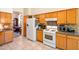 Well-equipped kitchen featuring wood cabinets, white appliances, and granite countertops at 9038 E Calle De Valle Dr, Scottsdale, AZ 85255