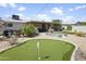 Expansive backyard featuring an outdoor kitchen under a patio, mini golf course, and comfortable seating areas at 912 E Orchid Ln, Phoenix, AZ 85020
