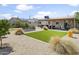 Landscaped backyard featuring an outdoor patio with seating, lawn, and manicured landscaping at 912 E Orchid Ln, Phoenix, AZ 85020