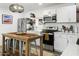 Beautiful kitchen featuring white cabinets, a mosaic backsplash, stainless steel appliances, and an island with seating at 912 E Orchid Ln, Phoenix, AZ 85020