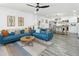 Bright open-concept living room with blue couches, a modern kitchen, and light gray wood floors at 912 E Orchid Ln, Phoenix, AZ 85020