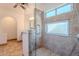 Bathroom featuring a tiled walk-in shower with a built-in seat and decorative stone flooring at 9371 E Wood Dr, Scottsdale, AZ 85260
