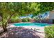 Backyard with a pool surrounded by mature trees and brick accents at 9371 E Wood Dr, Scottsdale, AZ 85260