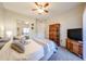 Bright bedroom features a ceiling fan, mirror, television, and wood armoire at 10030 W Indian School Rd # 101, Phoenix, AZ 85037