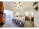 Comfortable bedroom with neutral color scheme, ceiling fan, and balcony access at 10030 W Indian School Rd # 101, Phoenix, AZ 85037