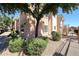 Exterior view of condo building with well-maintained landscaping, stairs, and tan stucco at 10030 W Indian School Rd # 101, Phoenix, AZ 85037
