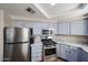 Updated kitchen with granite counters, stainless appliances, and light blue cabinets at 10030 W Indian School Rd # 101, Phoenix, AZ 85037
