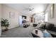 Spacious living room with plush carpeting, fan, and view of the kitchen at 10030 W Indian School Rd # 101, Phoenix, AZ 85037
