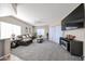Spacious living room with plush carpeting, fan, and adjacent TV area at 10030 W Indian School Rd # 101, Phoenix, AZ 85037