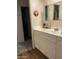 Bathroom with a vanity, storage cabinets and a mirror with decorative floral decor and view into another room at 120 N Val Vista Dr # 196, Mesa, AZ 85213
