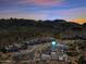 Stunning aerial view of a modern home nestled in a desert community with mountain views at sunset at 12746 E Casitas Del Rio E Dr, Scottsdale, AZ 85255