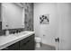 Modern bathroom with gray tiled wall, sleek white sink, and stylish black fixtures at 12746 E Casitas Del Rio E Dr, Scottsdale, AZ 85255