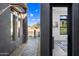 Inviting entryway with stone accents, desert landscaping, and a glimpse of the bright, modern interior at 12746 E Casitas Del Rio E Dr, Scottsdale, AZ 85255