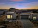 Exterior view of modern home at dusk featuring desert landscape, fire pit, and mountain views at 12746 E Casitas Del Rio E Dr, Scottsdale, AZ 85255
