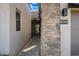 Front entrance featuring a stone accent wall, modern lighting, and a paved walkway at 12746 E Casitas Del Rio E Dr, Scottsdale, AZ 85255