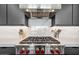 Close-up of cooktop with modern vent hood above and marble backsplash at 12746 E Casitas Del Rio E Dr, Scottsdale, AZ 85255