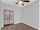 Neutral bedroom with wood flooring, a ceiling fan, and a closet with curtains at 1332 W Blue Ridge Ct, Chandler, AZ 85248