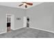 Large bedroom with doorways to the bathroom and hallway, featuring neutral carpeting and a ceiling fan at 1332 W Blue Ridge Ct, Chandler, AZ 85248