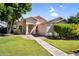 Charming single-story home boasts lush green lawn, mature landscaping, and covered front porch at 1332 W Blue Ridge Ct, Chandler, AZ 85248