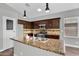 Bright kitchen featuring granite countertops, stainless steel appliances, and dark wood cabinetry at 1332 W Blue Ridge Ct, Chandler, AZ 85248