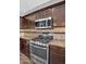 Close up of the modern stainless steel gas range, microwave and granite countertops at 1332 W Blue Ridge Ct, Chandler, AZ 85248