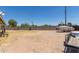 Spacious backyard with a block fence, boat, trailer, and sparse vegetation, under a clear blue sky at 1351 E Ellis Cir, Mesa, AZ 85203