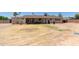Expansive backyard featuring dry grass, a covered patio, and mature trees, under a clear blue sky at 1351 E Ellis Cir, Mesa, AZ 85203