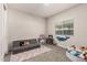 Spacious bedroom with gray sofa, soft rug, toys, and a bright window, perfect for ' play at 1360 E Avenida Kino --, Casa Grande, AZ 85122