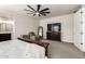 Comfortable main bedroom featuring a ceiling fan, TV, dresser, and cozy sitting area with a mirror at 1360 E Avenida Kino --, Casa Grande, AZ 85122