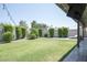 Serene backyard with manicured lawn, privacy landscaping, and a covered patio for relaxing and entertaining at 1401 E Drake Dr, Tempe, AZ 85283