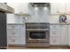 A stainless steel oven is surrounded by white cabinetry and countertops in this kitchen at 1401 E Drake Dr, Tempe, AZ 85283