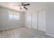 Bedroom with ceiling fan, neutral walls, wood-look tile flooring, and closet with sliding doors at 1526 W North Ln, Phoenix, AZ 85021