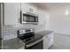 Modern kitchen area with stainless steel microwave and electric stove with updated countertops and tile at 1526 W North Ln, Phoenix, AZ 85021