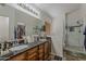 Bathroom with double sinks, dark countertops, and a walk-in shower at 16426 S 29Th St, Phoenix, AZ 85048