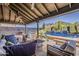 Inviting covered patio with stylish seating, ceiling fans, a clear view of a sparkling pool, and desert landscaping at 16426 S 29Th St, Phoenix, AZ 85048