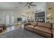 Open living room floor plan featuring a large leather couch, ceiling fan, and tile flooring throughout at 16426 S 29Th St, Phoenix, AZ 85048