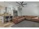 Open concept living room featuring tile flooring, a large leather sectional, ceiling fan, and kitchen bar at 16426 S 29Th St, Phoenix, AZ 85048